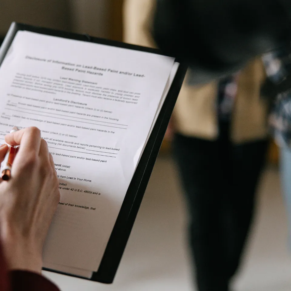 First-time homebuyer reviewing mortgage documents with a financial advisor at a desk.