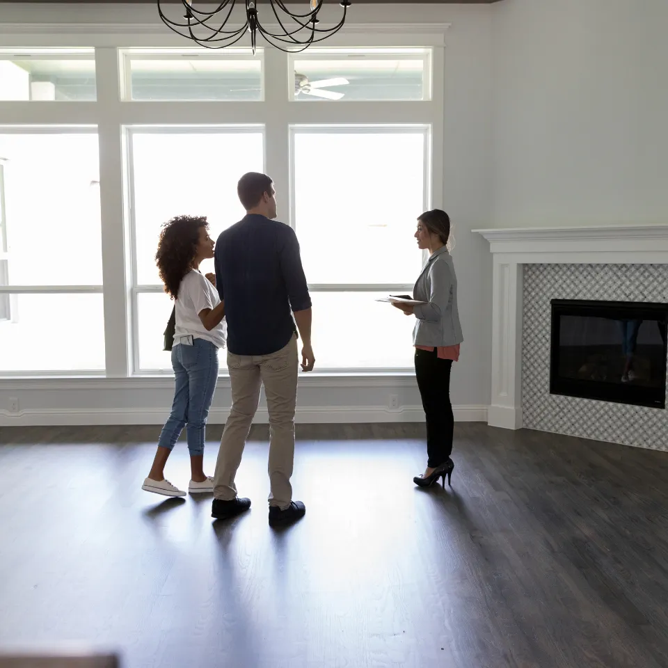 Couple touring a home with a real estate agent in a spacious living room, highlighting the home-buying process in North Atlanta.