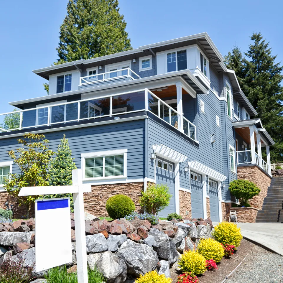 First-time home seller standing outside a tidy, staged home with a “For Sale” sign, highlighting key selling mistakes to avoid.