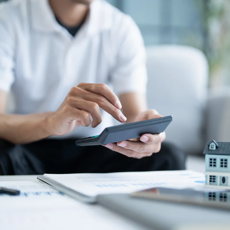 Young boy reviewing finances with a laptop and mortgage paperwork, symbolizing the first step to buying a home.