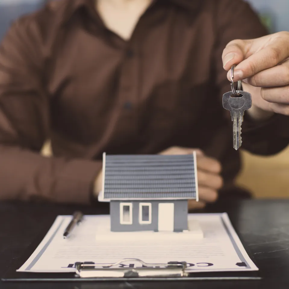 Split image: “For Sale” sign vs. couple holding new home keys.
