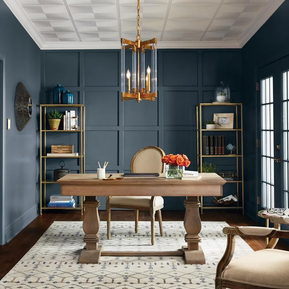 Stylish home office featuring a wooden desk, elegant chair, and decorative shelving, with a blue accent wall and floral centerpiece, ideal for productivity and design inspiration.