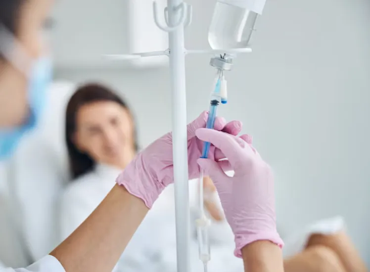 Experienced caucasian heath care worker preparing a dark-haired female patient for the intravenous vitamin therapy