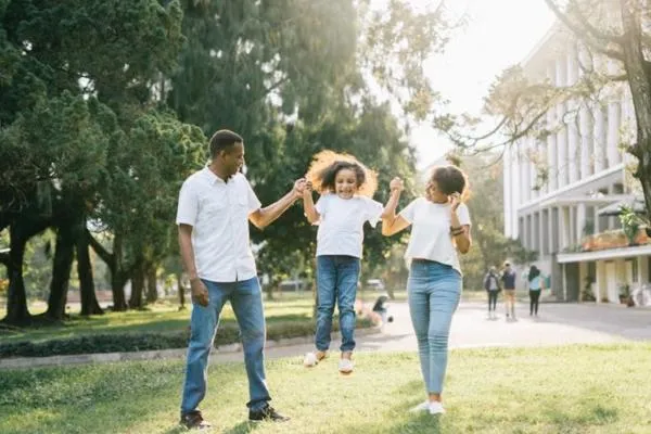 Happy family in a park - From Punishment to Guidance: A Kinder Approach to Everyday Parenting Challenges