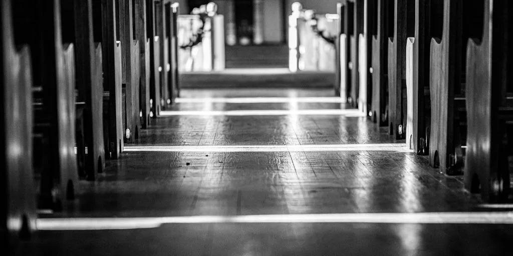 Aisle of old country in church in black and white.  