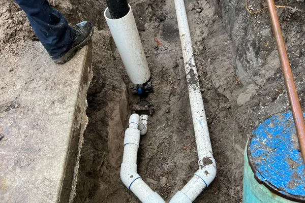 Turbo Plumbing Plumber in Tampa fixing something wearing a turbo plumbing shirt
