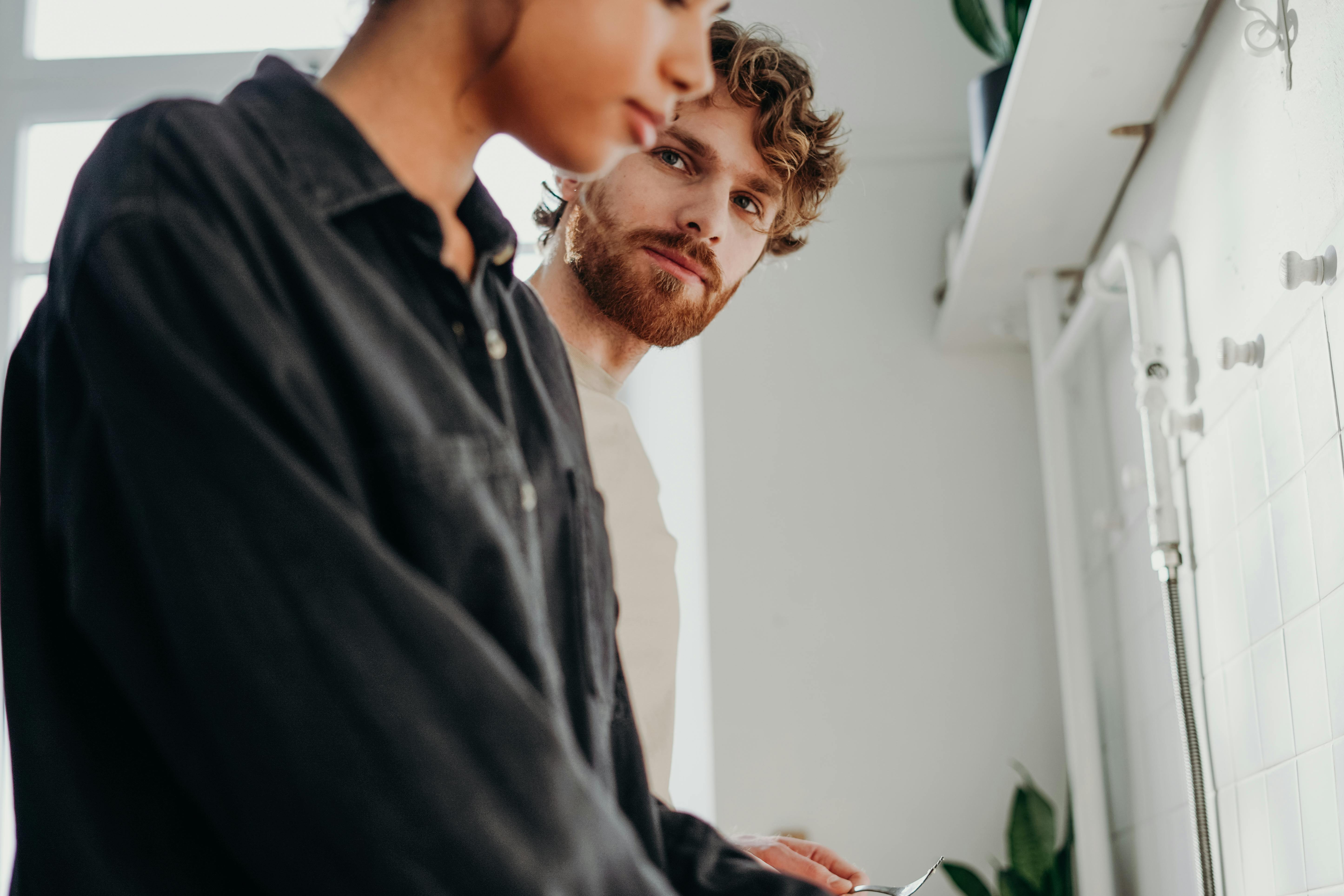 A man stares intensely at his girlfriend while they both appear tense and struggle with boundaries in their relationship.