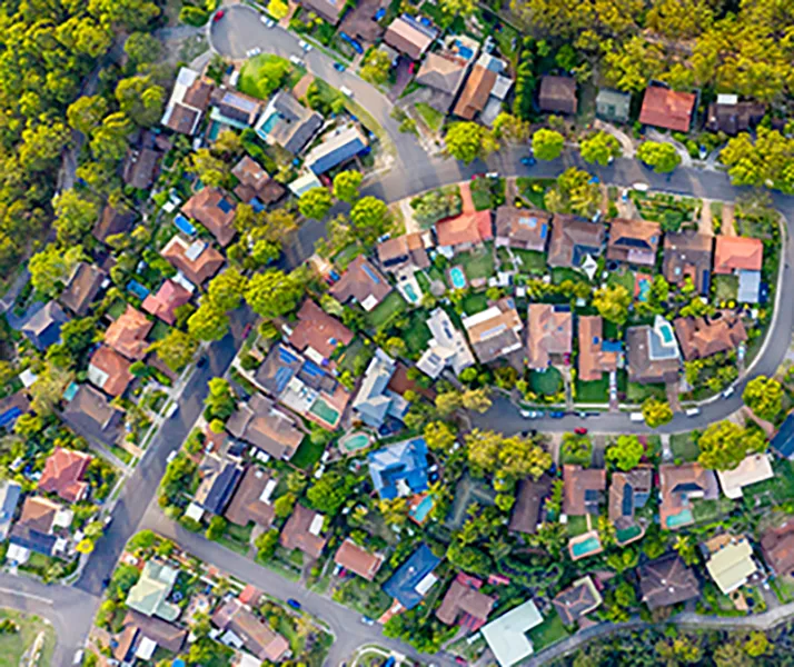 Aerial view of green suburban neighbourhood with well-kept homes and trees.