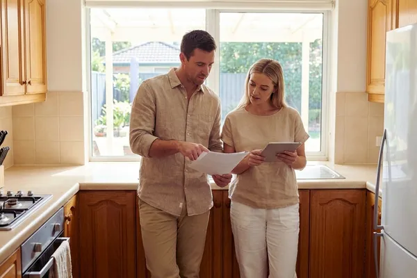 Buyers reviewing renovation costs inside a dated Sunshine Coast kitchen before deciding whether to renovate or walk away