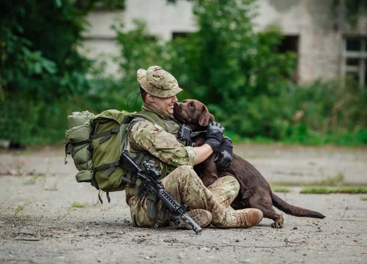 A US Army soldier sitting with a dog