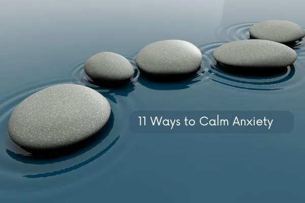 11 Mindfulness Activities to Calm Anxiety in 2024 title, with calm water and some pebbles laying in the water.