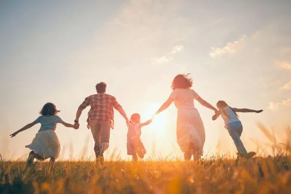 a family running in the hills holding hands.