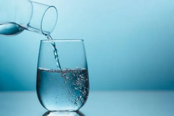 blue background, with a glass of water being poured.