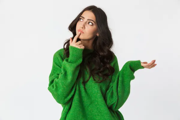 Female in a green long jumper looking thoughtful