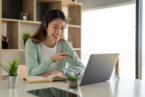 Lady working at a laptop looking happy.