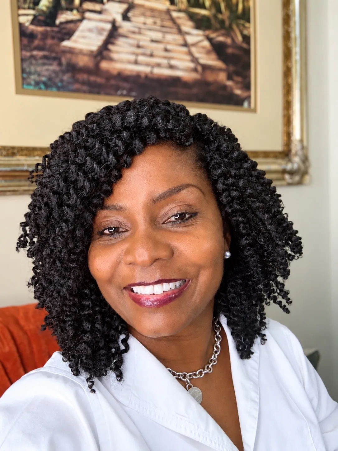 Coach Michelle smiling with curly hair in a white shirt