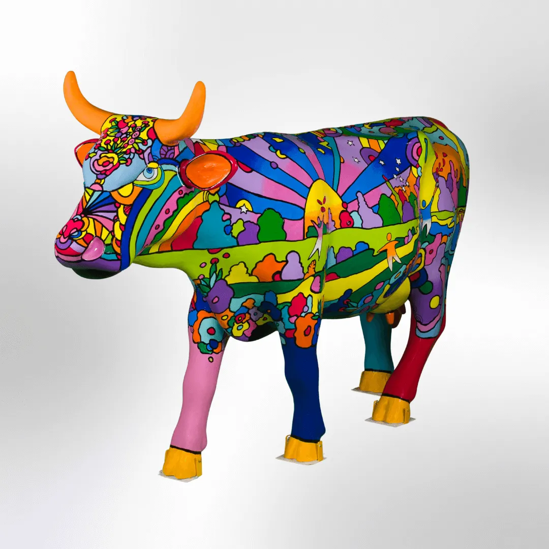 A bold, pop art designed cow depicting people enjoying a day at the park