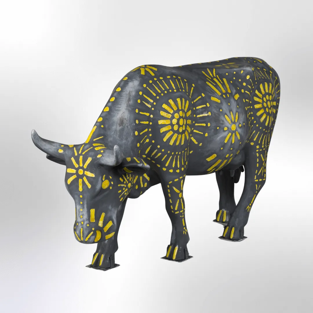 A silver cow punched like a 19th-century tin lantern with sunbursts of yellow