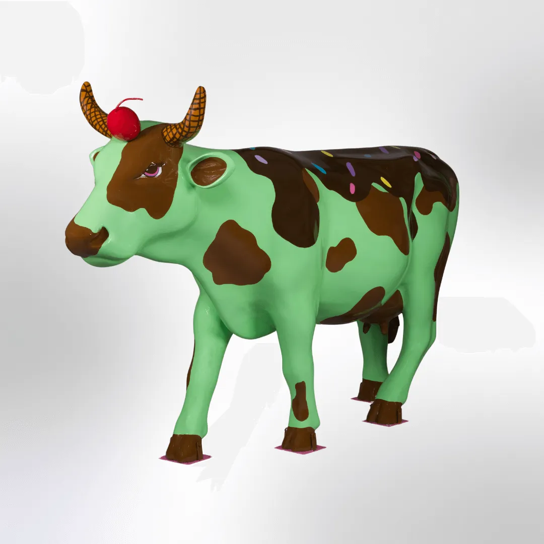 A cow sculpture decorated like a mint chocolate chip ice cream sundae, complete with horns that look like waffle cones and a cherry on the forehead