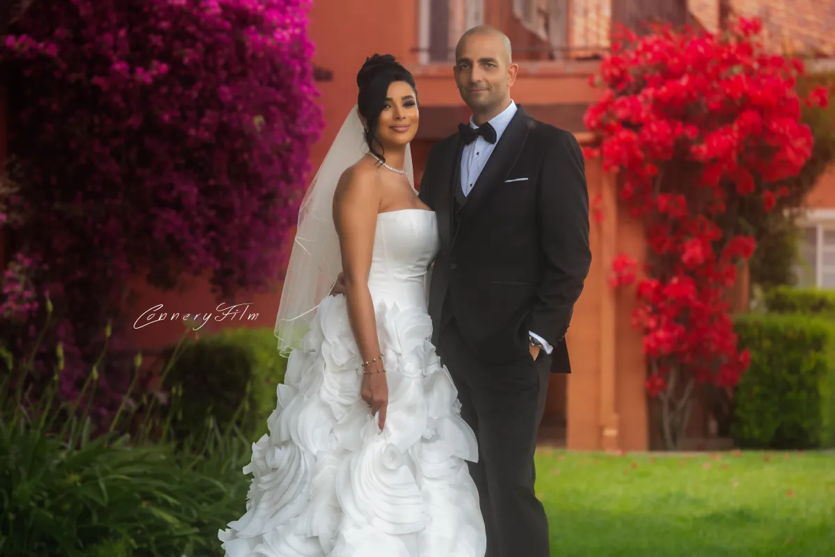 Bride Niki and groom Peyman smiling and embracing during their first dance at their outdoor wedding.