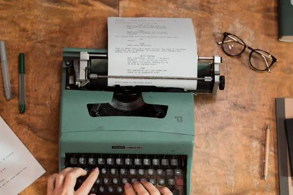 A typewriter and person typing a script