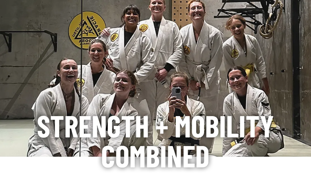 A group of women in jiujitsu gi's taking a selfie in front of a mirror