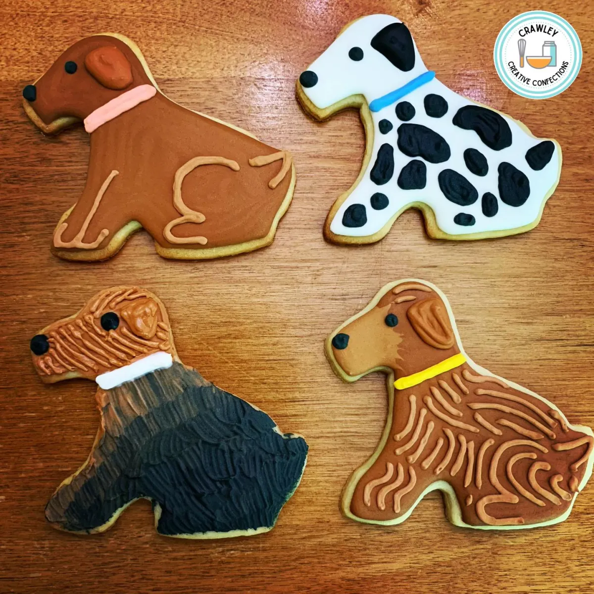 A charming assortment of sugar cookies shaped like different dog breeds sitting, each decorated with meticulous hand-iced details. The designs capture the unique fur patterns, colors, and features of various breeds, including golden retrievers, pugs, dalmatians, and huskies. Each cookie showcases the personality and adorable posture of the dogs, creating a delightful and diverse display.