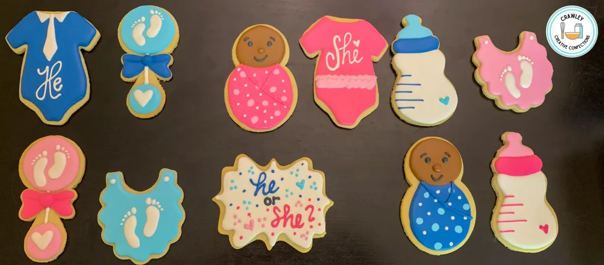 A heartfelt set of sugar cookies for a gender reveal, featuring a baby of color design surrounded by pink and blue themed cookies. The decorations include delicate hand-iced details like baby onesies, hearts, and playful accents representing both girl and boy themes. The cookies beautifully celebrate diversity and anticipation in a sweet and meaningful way.