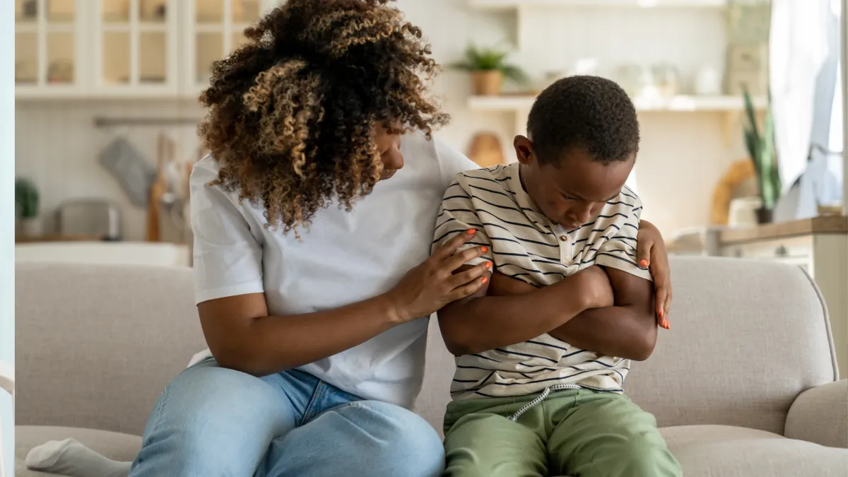 Mãe abraçando a criança após uma birra, mostrando acolhimento, empatia e vínculo emocional.
