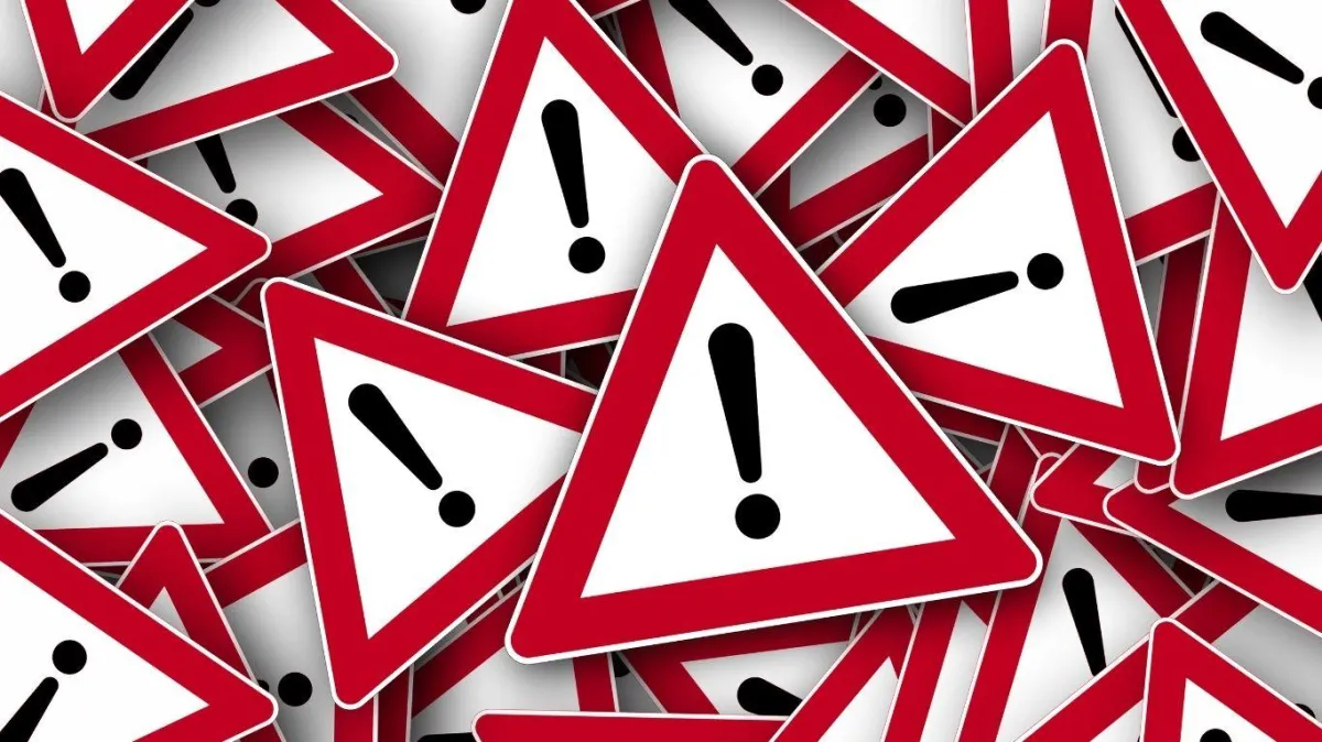 Pile of red and white triangular warning signs with black exclamation marks