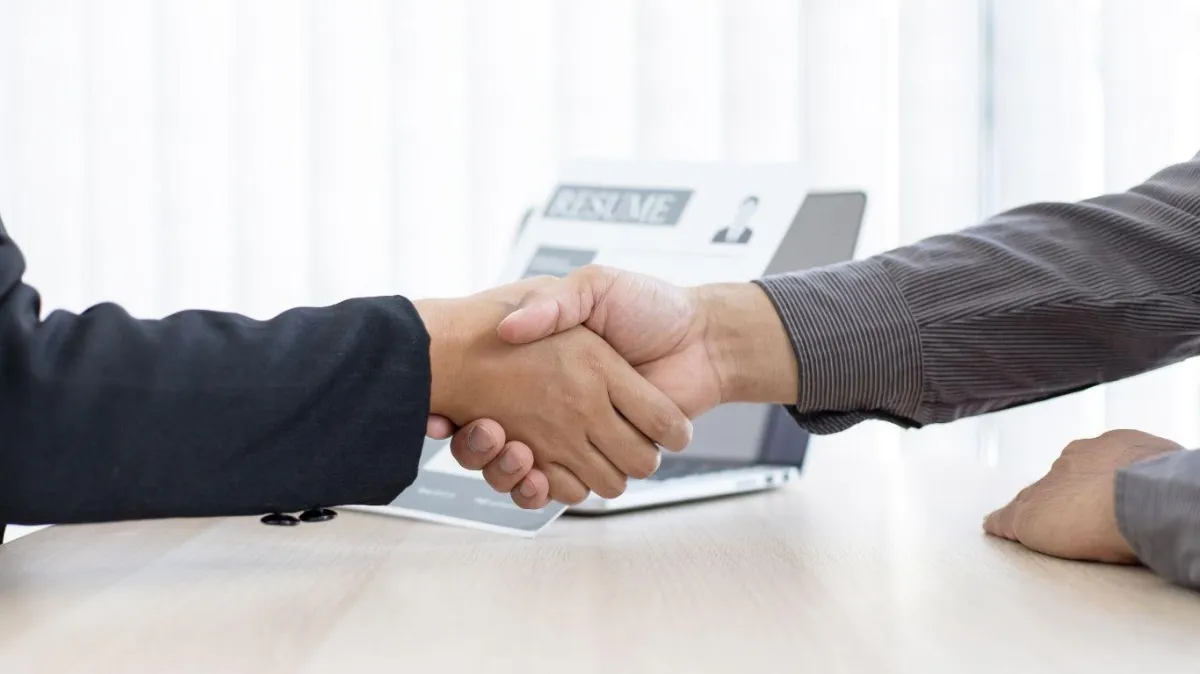 Employer welcomes new employee, shaking hands