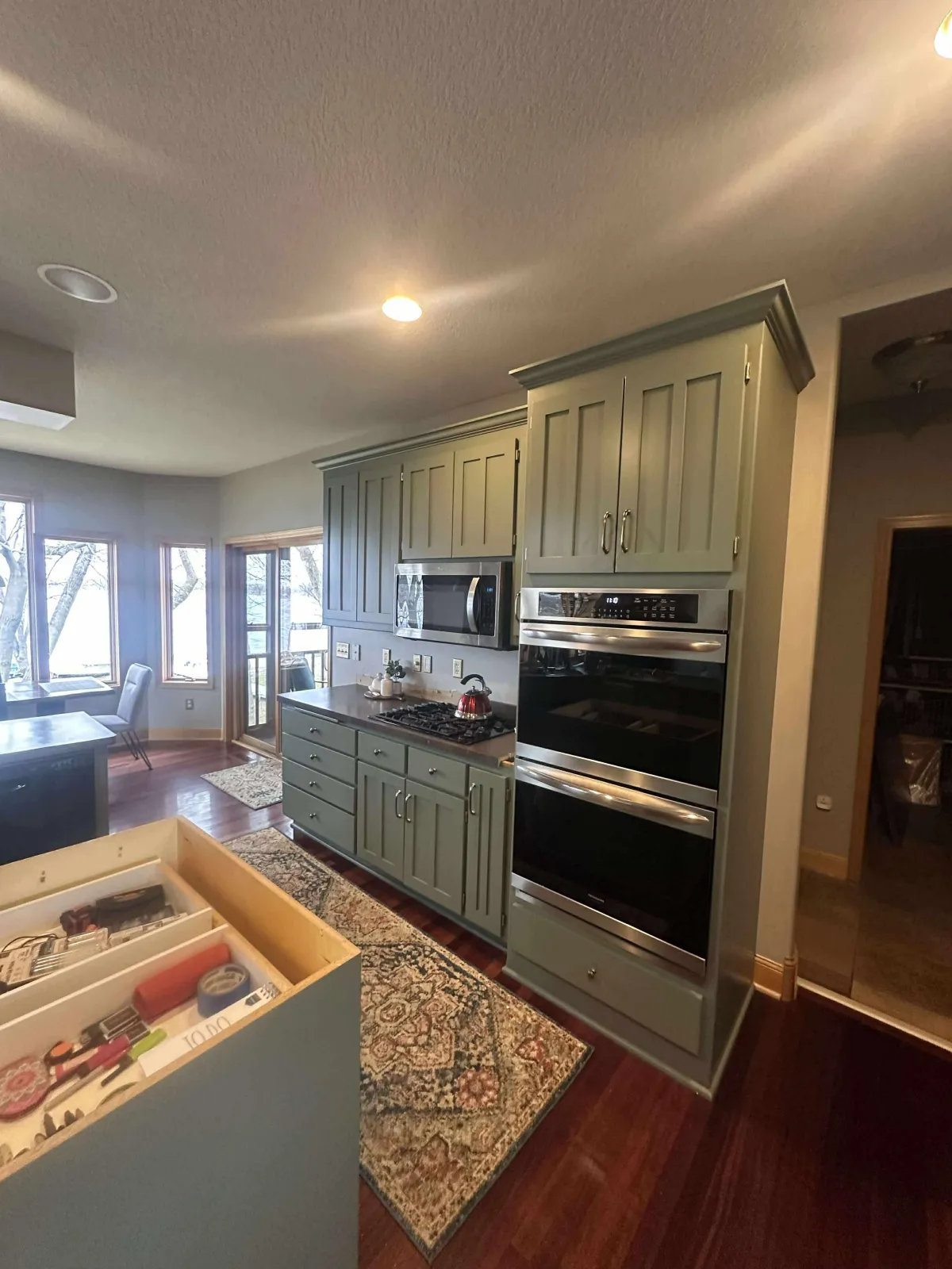 Olive green painted kitchen cabinets after interior repaint