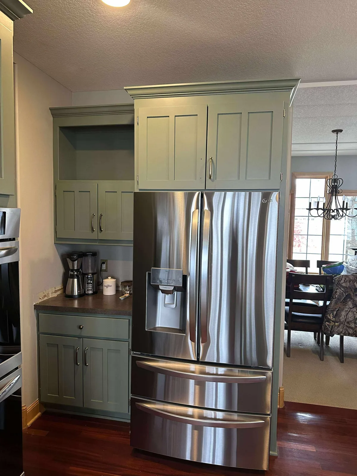 Kitchen cabinets painted in olive green with a clean, modern finish