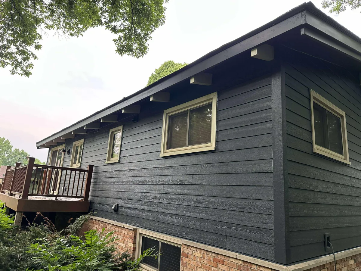 Dark blue house exterior with white trim after professional painting