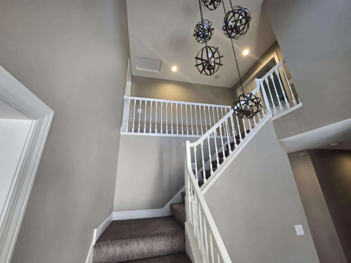 Freshly painted stairwell with white trim and neutral walls after interior repaint
