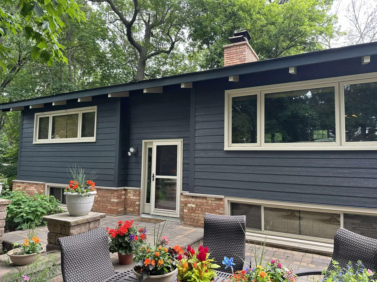 Dark blue ranch-style house with fresh white trim after a full exterior paint job