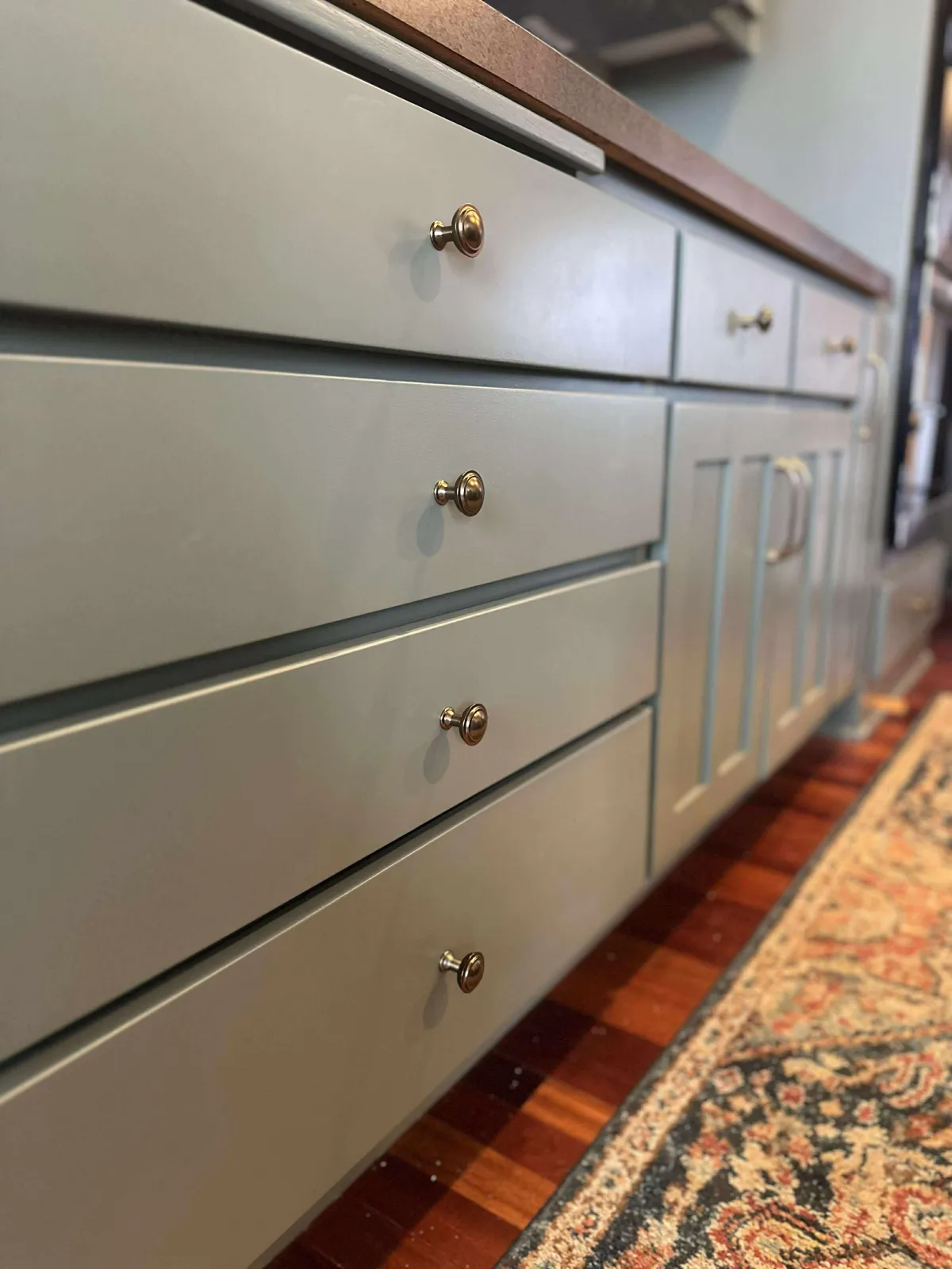 Close-up of olive green painted kitchen cabinet with smooth, clean finish