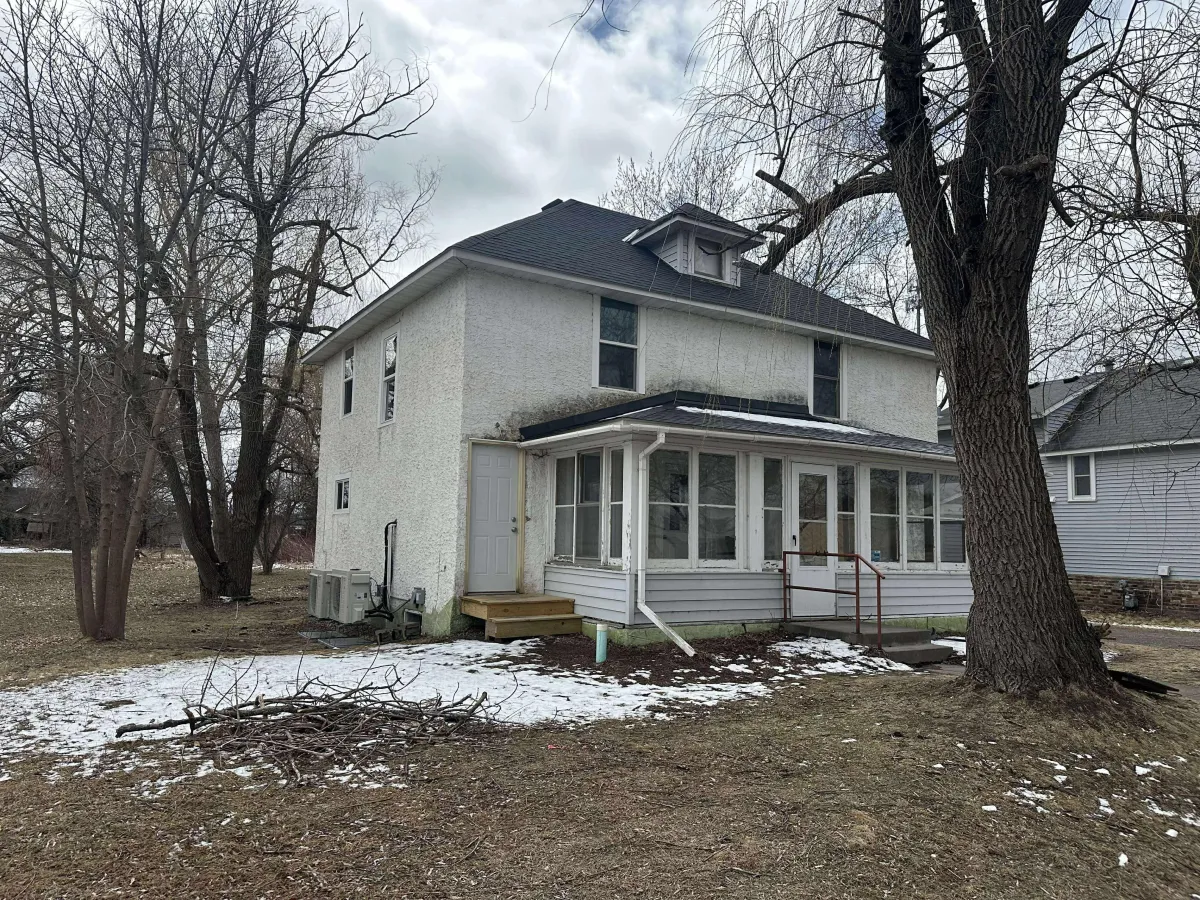 Faded house exterior before repainting, showing worn siding and dull color