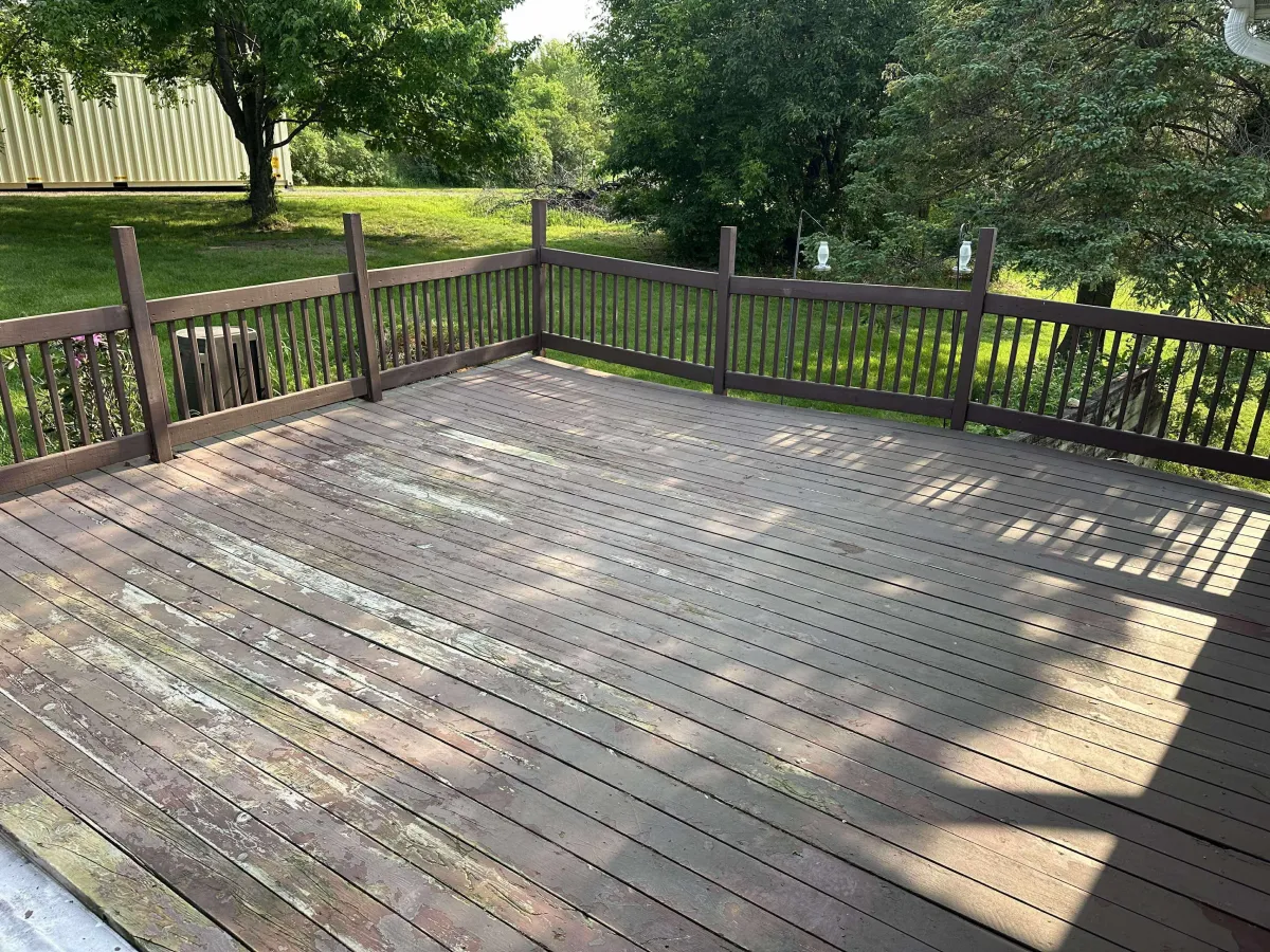 Weathered and faded backyard deck before professional refinishing