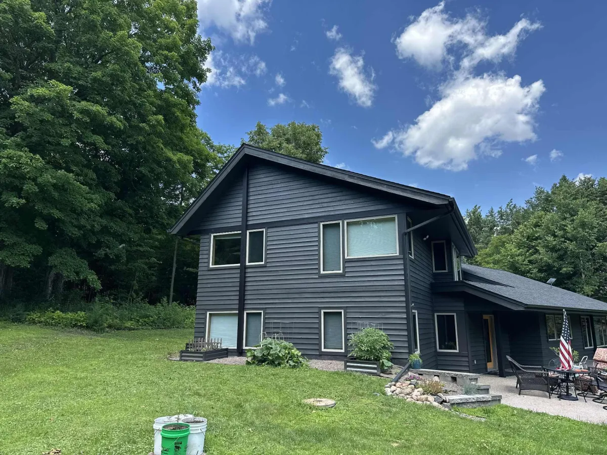 Front view of house with dark gray exterior and black trim after repaint