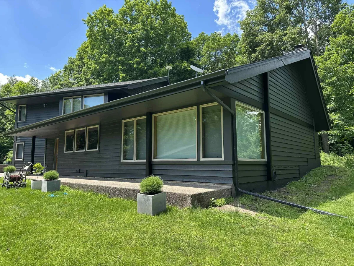 Side view of house with dark gray exterior and black trim after professional repaint