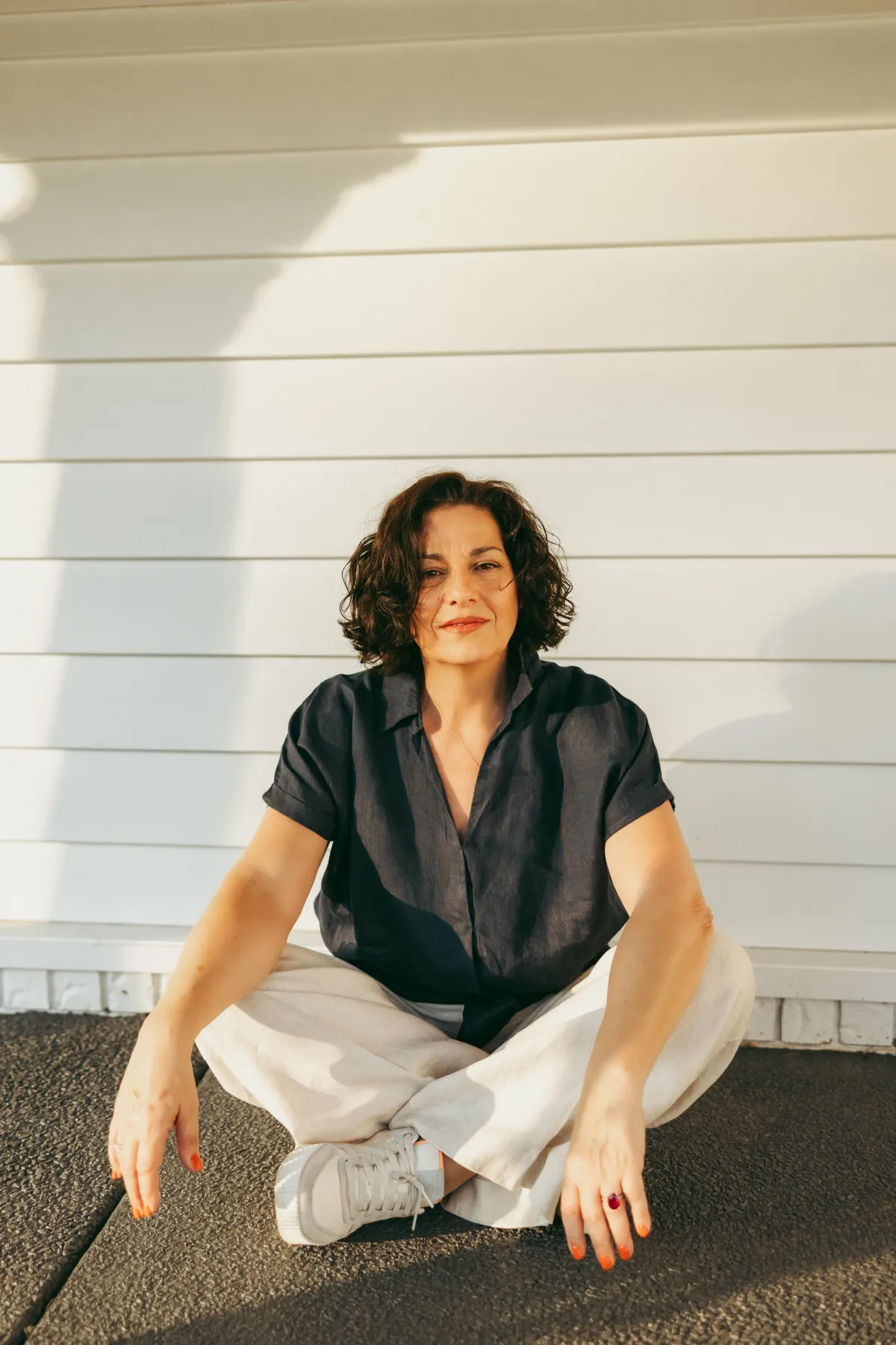 Midlife woman smiling during photoshoot, embracing natural beauty and menopause changes.