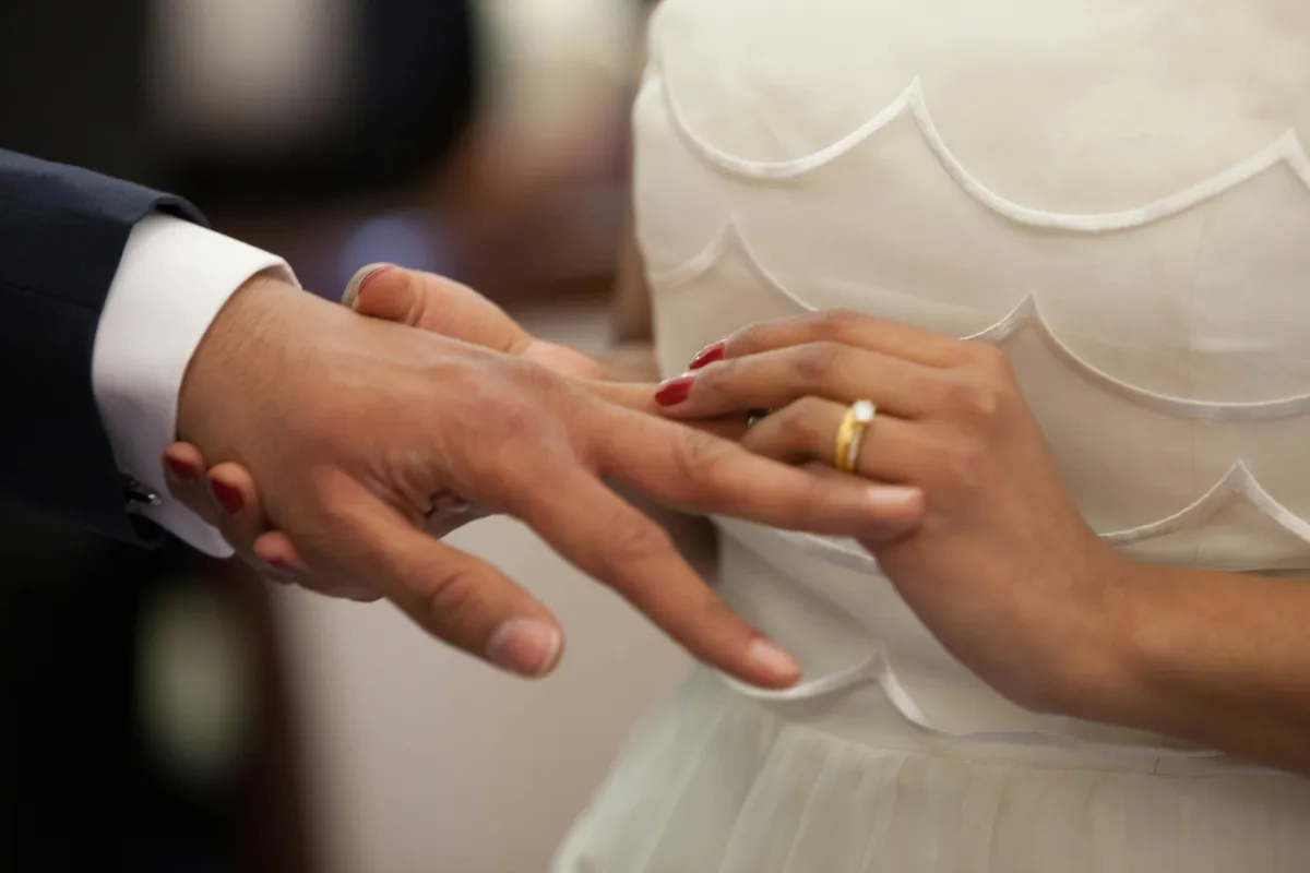 A pair of elegant wedding rings resting on a bed of delicate white flowers, symbolizing the journey from engagement to marriage.