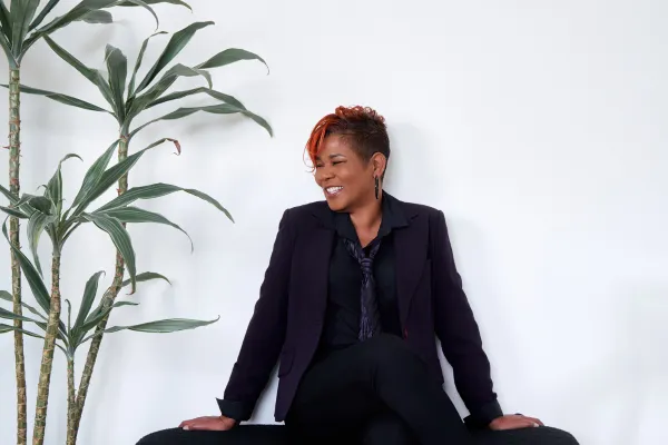 Amber Wynn in black suit laughing