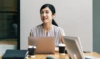 asian woman at a desk with laptop