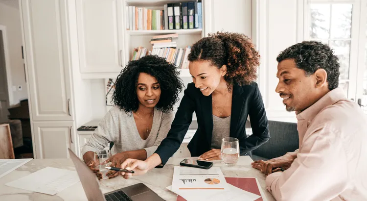 Real estate consultation, three people discussing documents, real estate agent, clients, home buying process, home selling strategy, financial planning, property market analysis, professional meeting, real estate planning.
