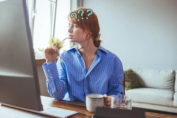 A woman with brain fog looking at a computer screen trying to remember
