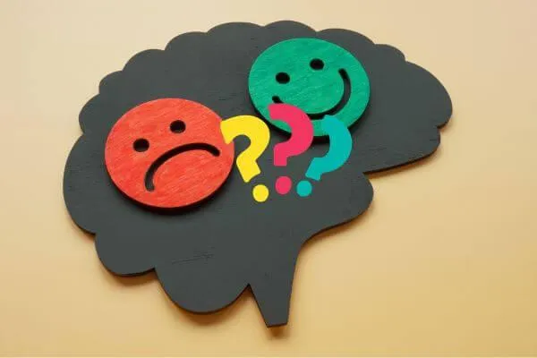 Picture of brain with happy and sad face and question marks