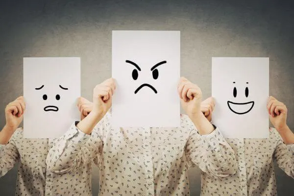 3 women holding up placards with sad frowning and smiley faces