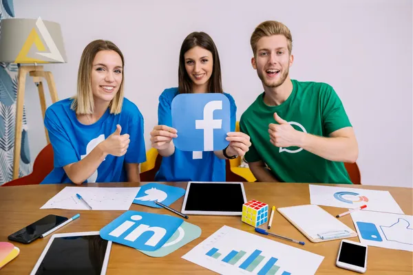 A group of marketers holding a sign with the facebook logo